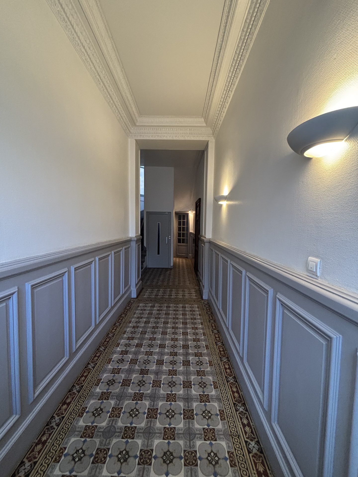 Hall d'immeuble moderne et lumineux, parfaitement entretenu